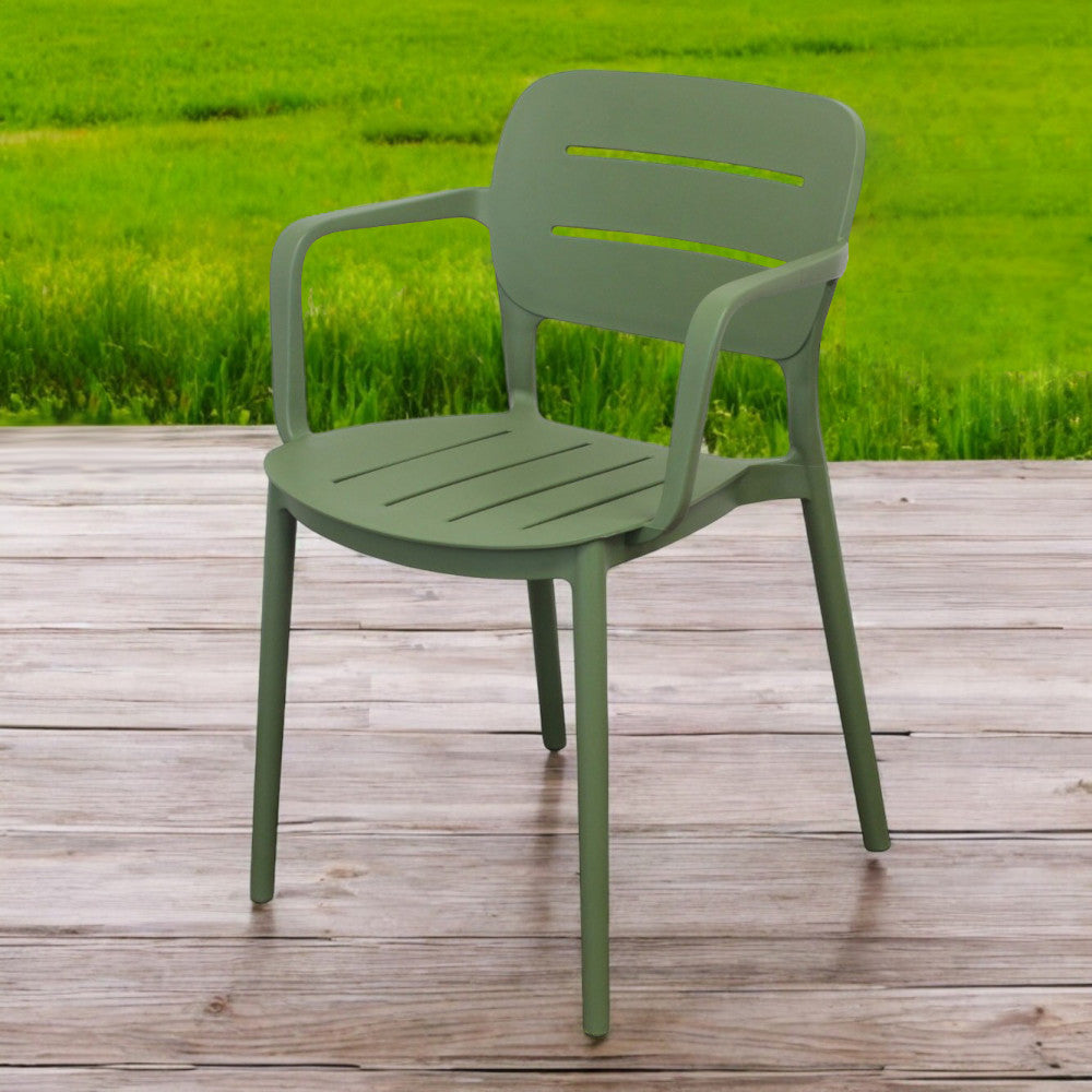 Poltrona Giselle posizionata su una pavimentazione in legno con un prato verde sfocato sullo sfondo.