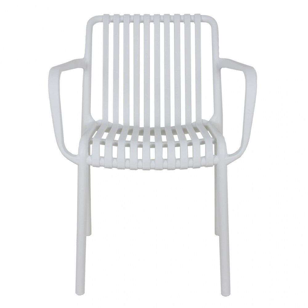 Poltrona Giuly colore Bianco, impilabile, con braccioli, ambientata in un giardino soleggiato.