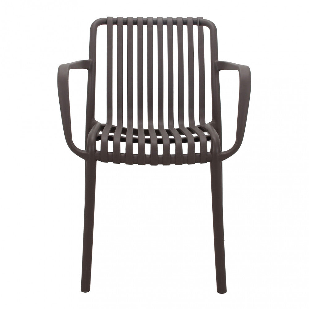 Poltrona Giuly colore Taupe, impilabile, con braccioli, ambientata su un patio esterno.