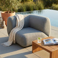 Poltrona laterale Vancouver grigia a bordo piscina con coperta chiara.