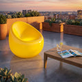 Poltrona luminosa gialla vibrante che brilla su una moderna terrazza panoramica al tramonto.