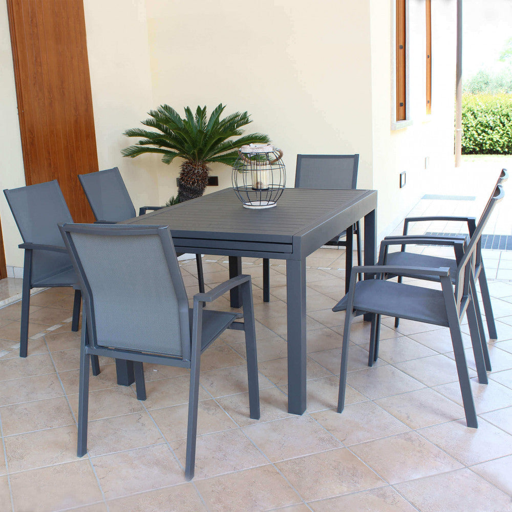 Set da pranzo outdoor composto da un tavolo grigio e sei poltrone Maili in alluminio antracite su un patio piastrellato.