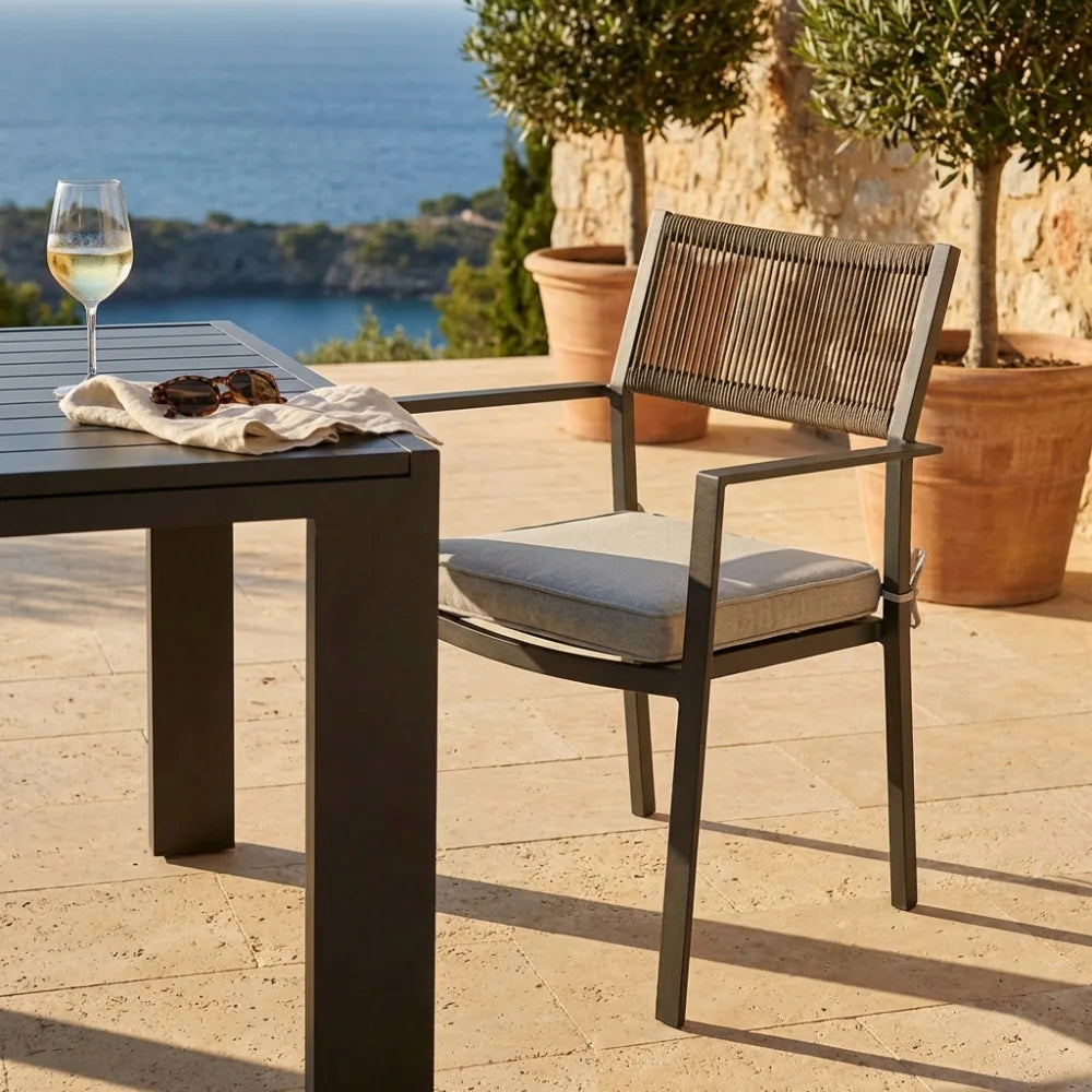 Poltrona Maracay in corda di poliestere taupe beige ambientata su una terrazza panoramica con vista mare.