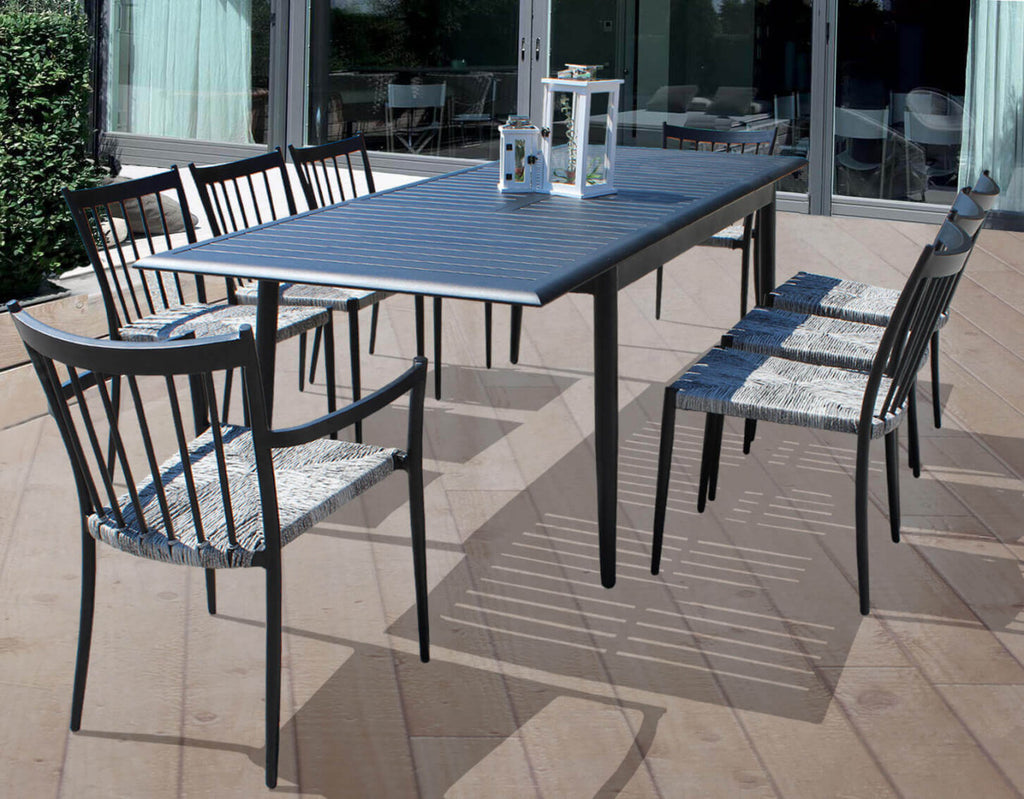 Set da pranzo outdoor composto da un grande tavolo rettangolare e sei poltrone Martinica impilabili su una terrazza moderna.