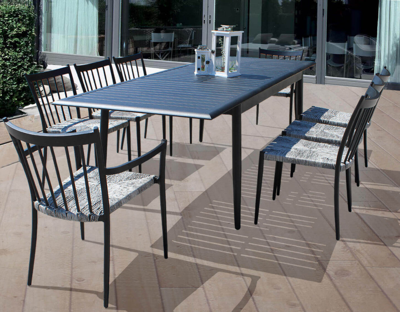 Set da pranzo outdoor composto da un grande tavolo rettangolare e sei poltrone Martinica impilabili su una terrazza moderna.