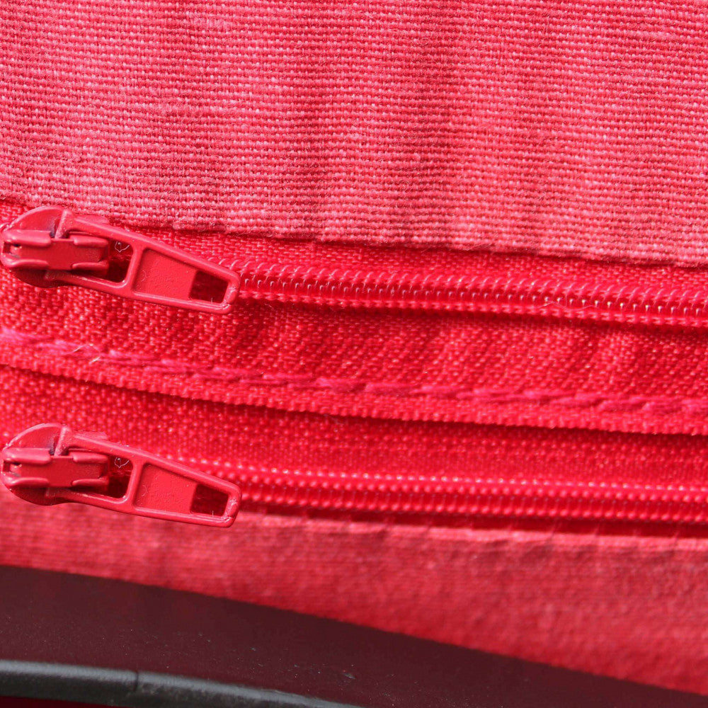 Macro della trama del tessuto rosso antico con cerniere tono su tono.