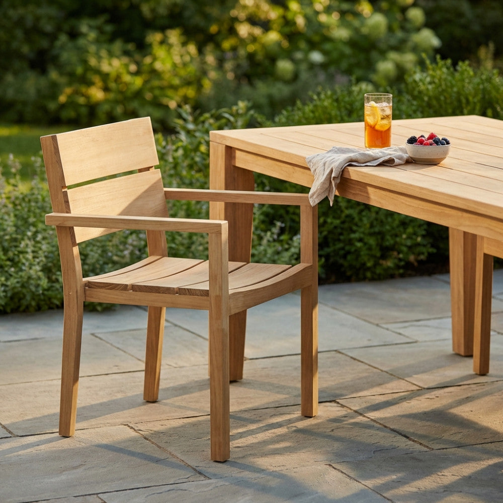 Dettaglio della Poltrona Parker in teak senza cuscino, inserita in un elegante contesto outdoor con tavolo e bevande.