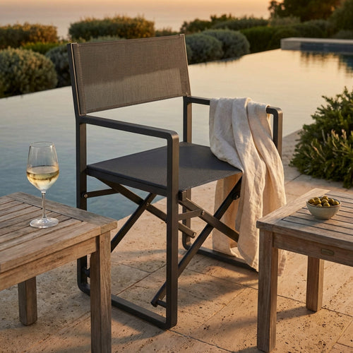 Poltrona regista Larissa in alluminio antracite ambientata a bordo piscina al tramonto con un bicchiere di vino.