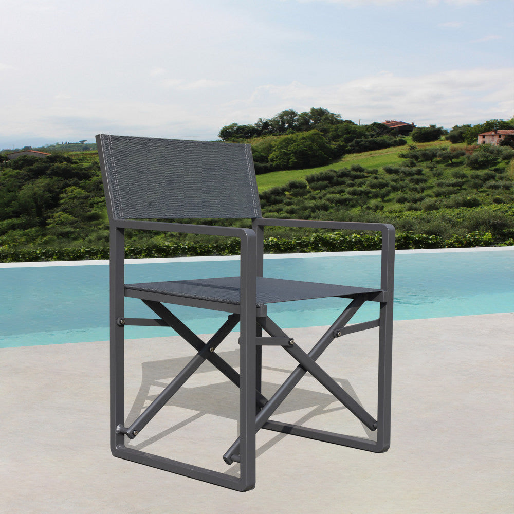 Poltrona regista Larissa posizionata su una terrazza in cemento con vista su un paesaggio collinare.