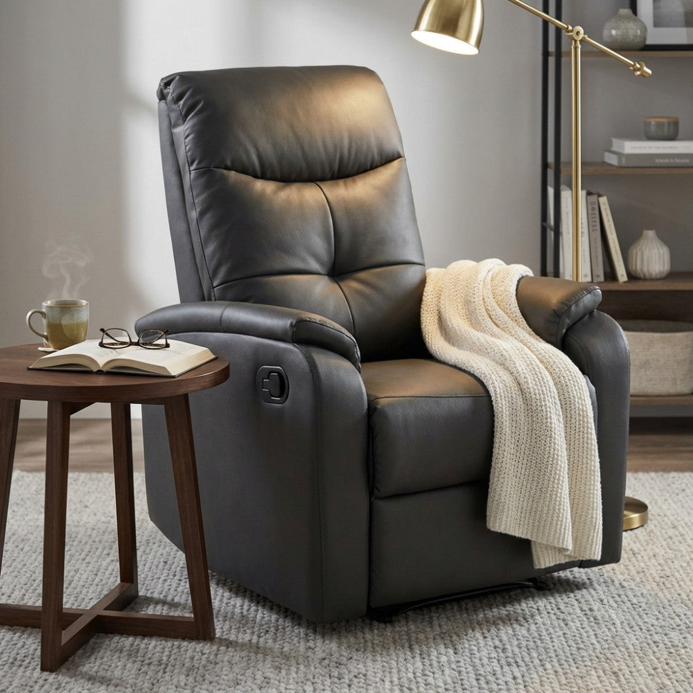 Dettaglio della poltrona relax grigia in un elegante angolo lettura, arricchita da una coperta in maglia chiara e illuminata da una lampada da terra.