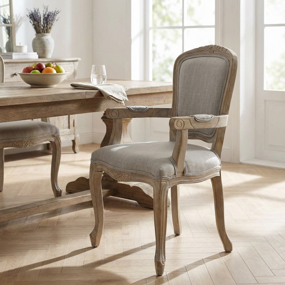 Poltrona Romy con braccioli in primo piano, posizionata in un luminoso soggiorno dal design classico contemporaneo.