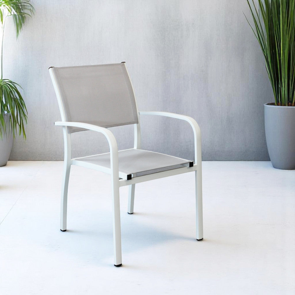 Poltrona Savannah bianca posizionata in un ambiente minimalista con pavimento chiaro e pianta ornamentale.