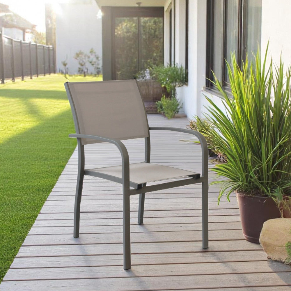 Poltrona da esterno Savannah posizionata su un patio in legno con prato verde e piante decorative sullo sfondo.