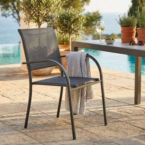 Poltrona Stamford in textilene taupe ambientata a bordo piscina con tavolo e calice di vino.