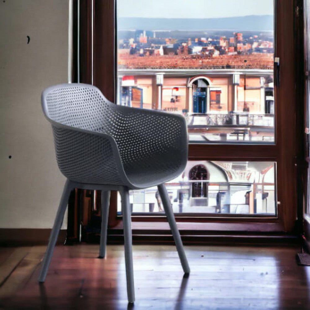 Poltrona Vannes posizionata in un interno moderno vicino a una grande finestra con vista panoramica sulla città.
