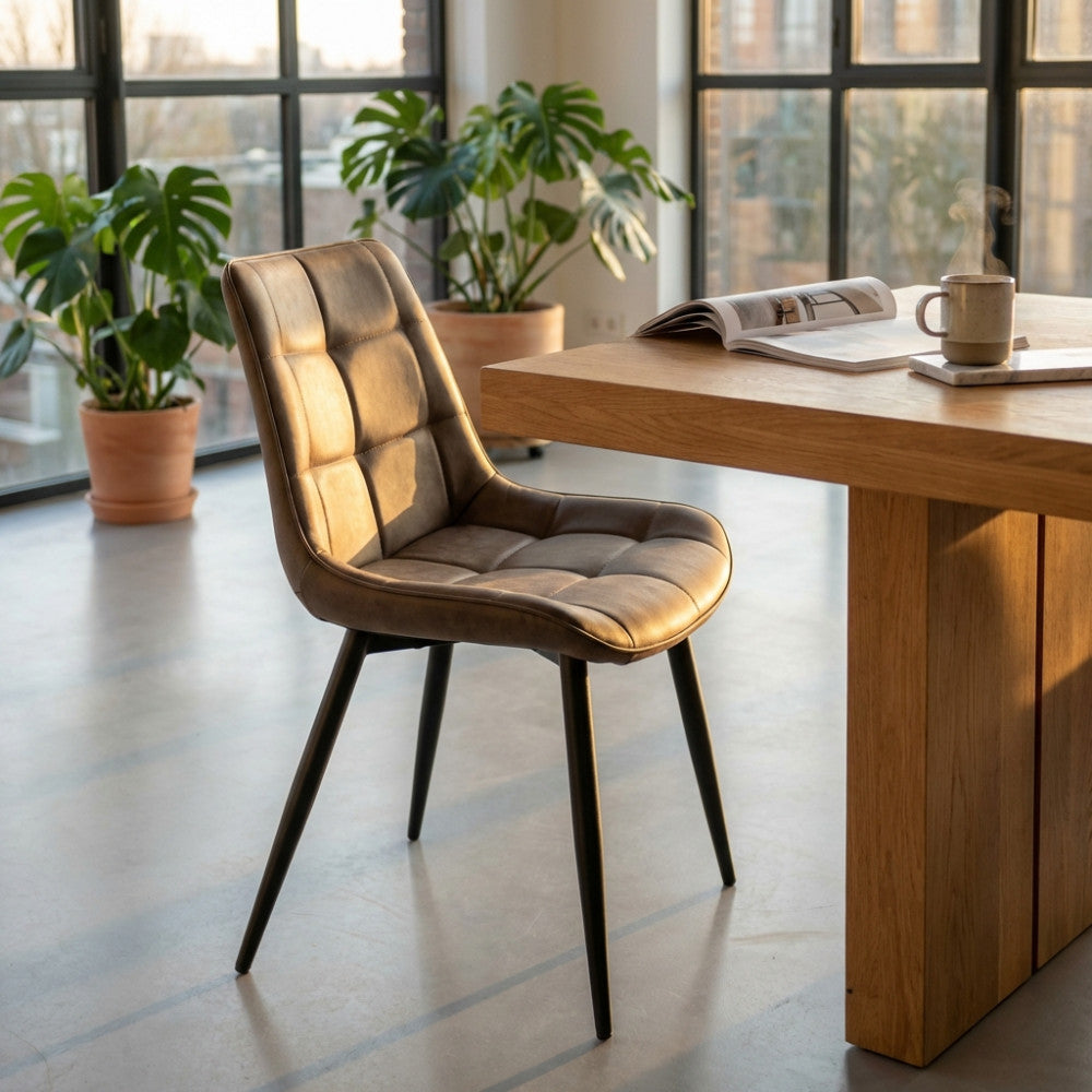 Poltrona Winona in ecopelle marrone e metallo, ambientata in una sala da pranzo moderna e luminosa.