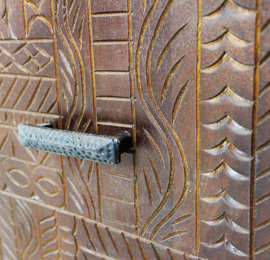 Dettaglio macro delle incisioni geometriche e ondulate sul legno di mango, con focus sulla maniglia in metallo martellato.