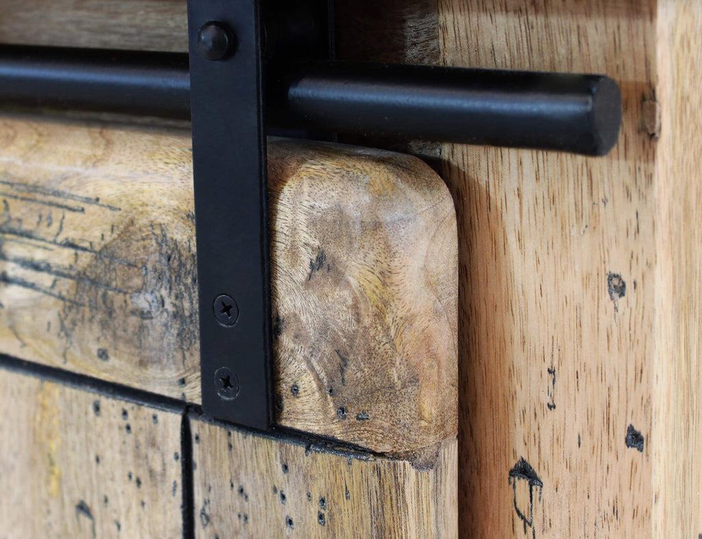 Dettaglio ravvicinato del binario in metallo nero e dell'anta scorrevole in legno del Porta TV Vaughan.