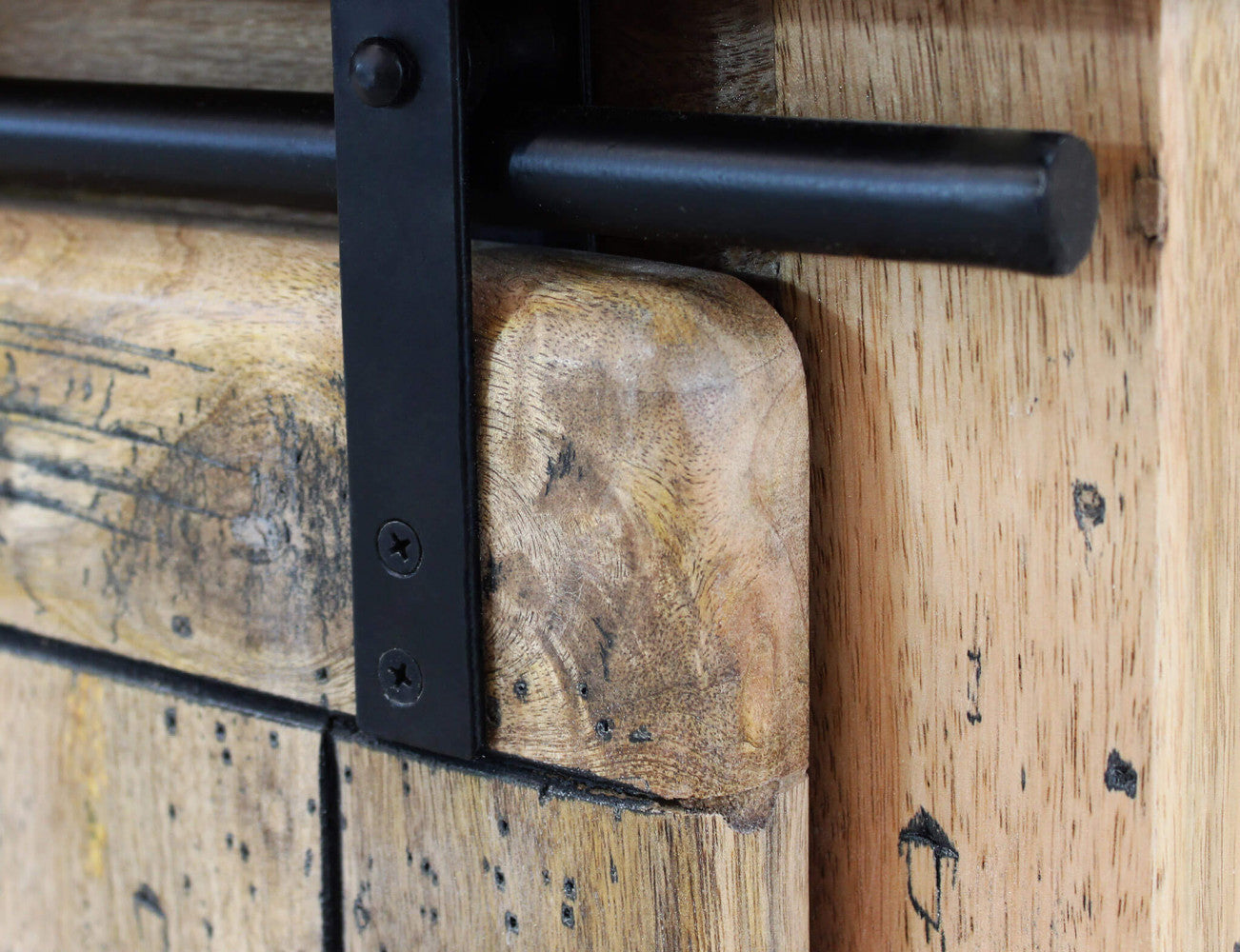 Dettaglio ravvicinato del binario in metallo nero e dell'anta scorrevole in legno del Porta TV Vaughan.