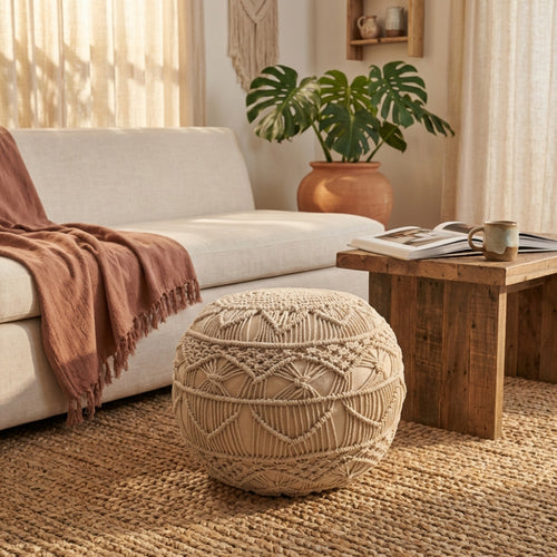 Pouf Bodrum in cotone bianco posizionato su un tappeto in iuta in un soggiorno boho-chic con divano in lino.
