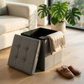 Pouf contenitore quadrato in ecopelle grigio aperto in un salotto luminoso con divano bianco.