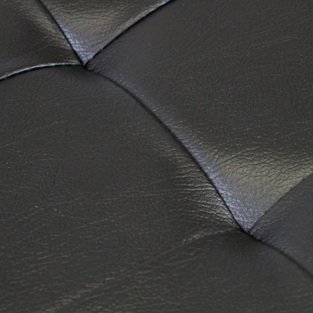 Dettaglio ravvicinato della superficie in ecopelle nera del pouf, che mostra la texture materica e le impunture della lavorazione capitonné.