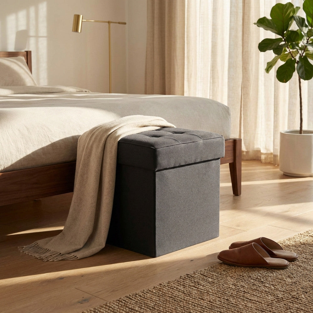 Pouf contenitore in tessuto nero decorato con un plaid beige in un ambiente moderno.