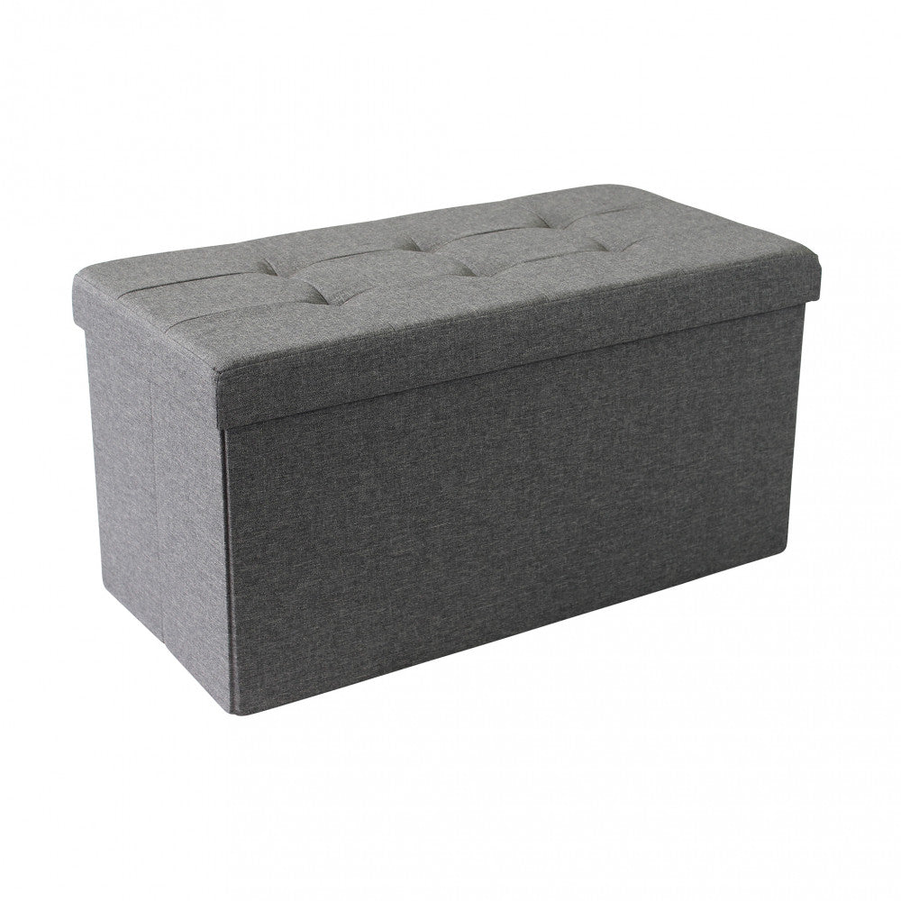 Vista isolata del pouf contenitore rettangolare chiuso, che mostra il design geometrico e il rivestimento in tessuto grigio scuro su sfondo bianco.