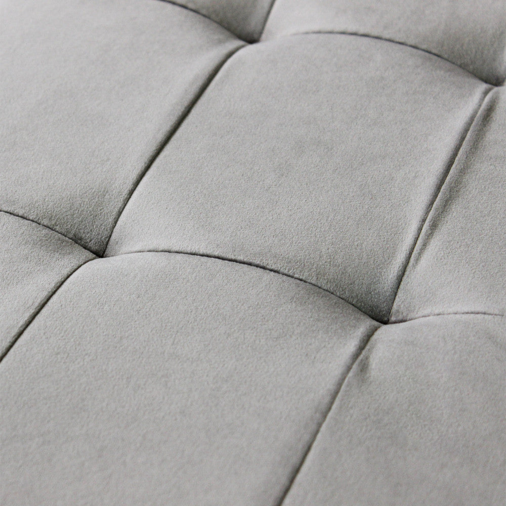 Dettaglio ravvicinato della lavorazione capitonné sul coperchio del pouf in velluto tortora, che esalta la texture del tessuto.