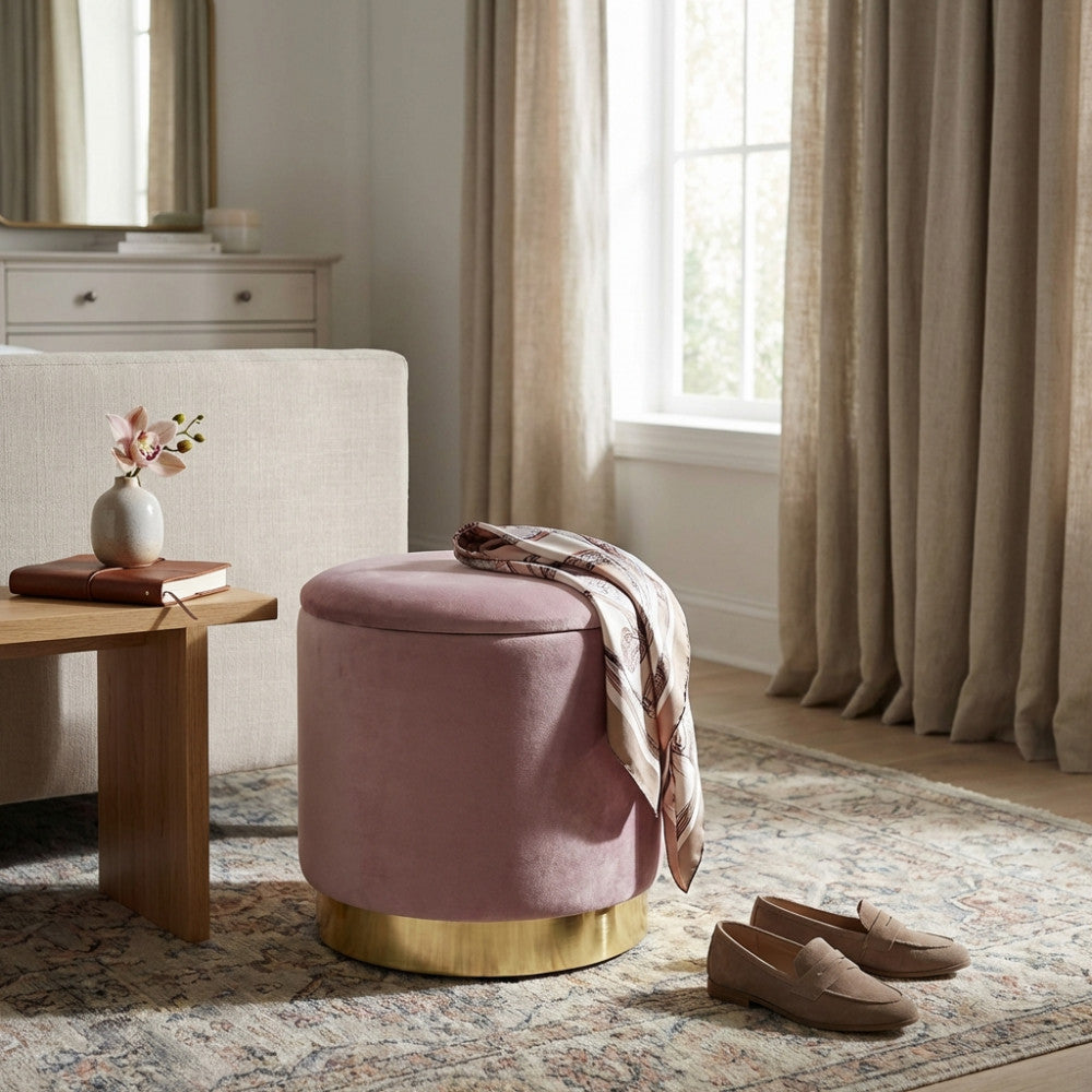 Pouf rotondo rosa con base dorata inserito in un elegante salotto dai toni neutri.