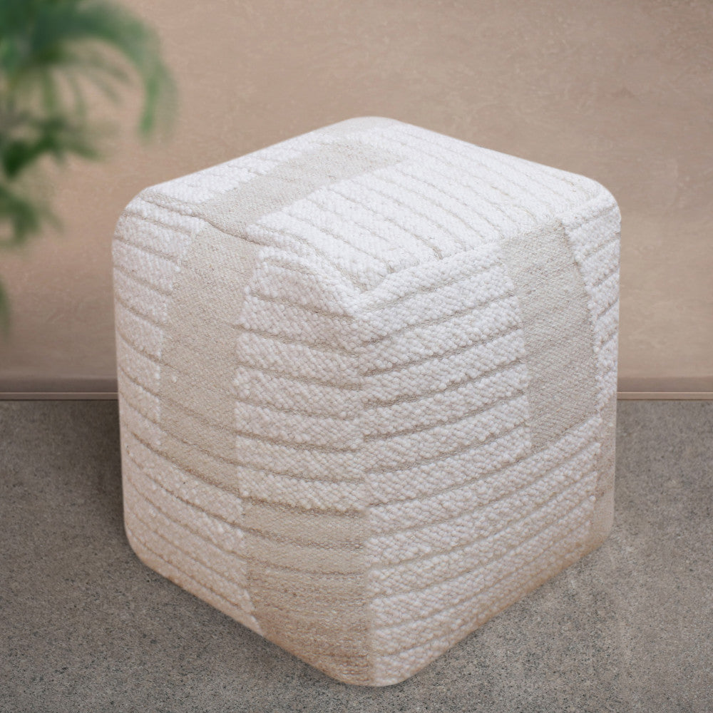 Pouf Josselin ambientato in uno spazio minimalista, con un focus ravvicinato sulla texture materica e le finiture artigianali.