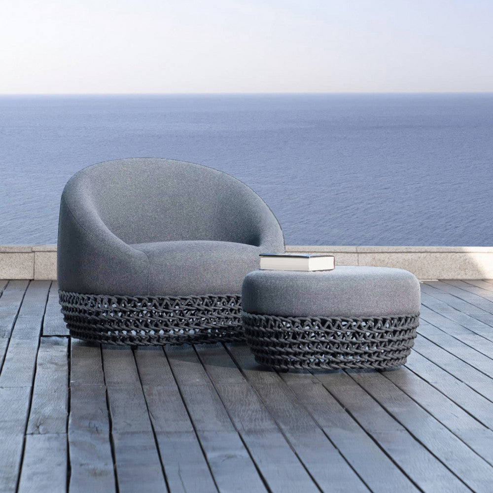 Pouf Lafayette abbinato alla poltrona coordinata su un patio in legno con vista mare.