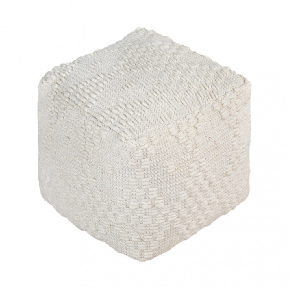 Vista in studio dettagliata del Pouf Marcel che evidenzia i complessi motivi geometrici intrecciati in lana e cotone su sfondo bianco puro.