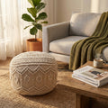 Pouf MILAS in cotone bianco con lavorazione macramè, ambientato in un accogliente soggiorno boho chic accanto a un divano grigio e un tavolino in legno.