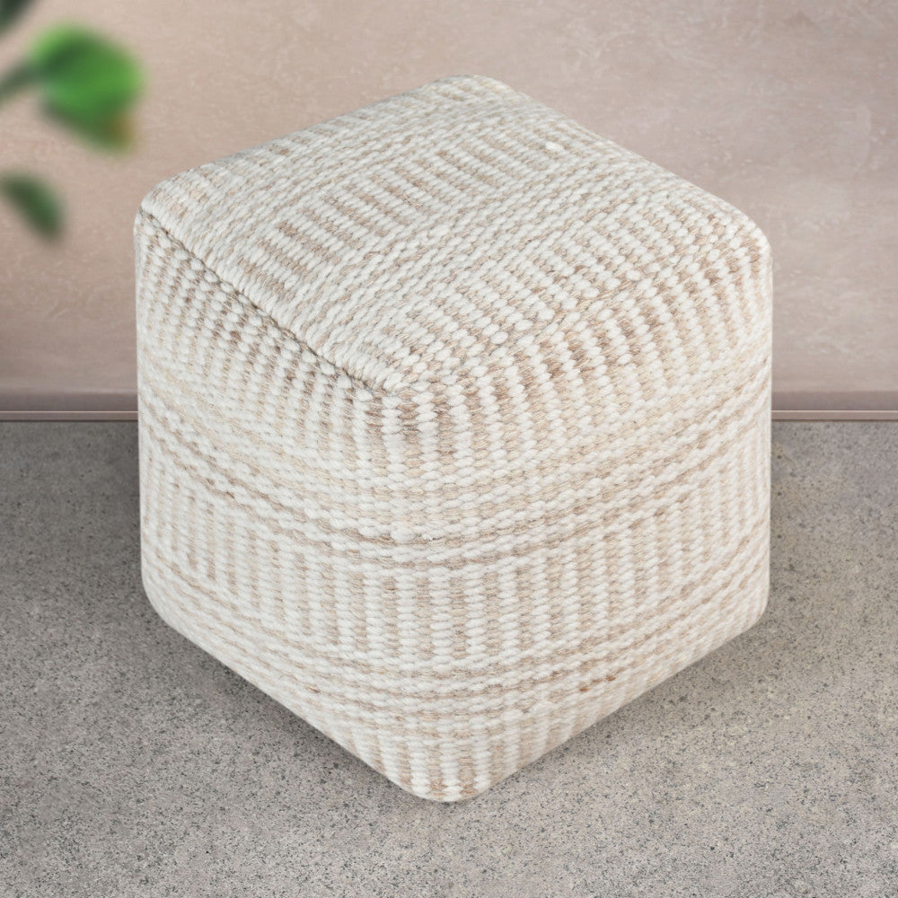 Pouf Roméo in lana e cotone bianco ecrù, ambientato su un pavimento in pietra chiara per esaltarne la geometria e la texture.