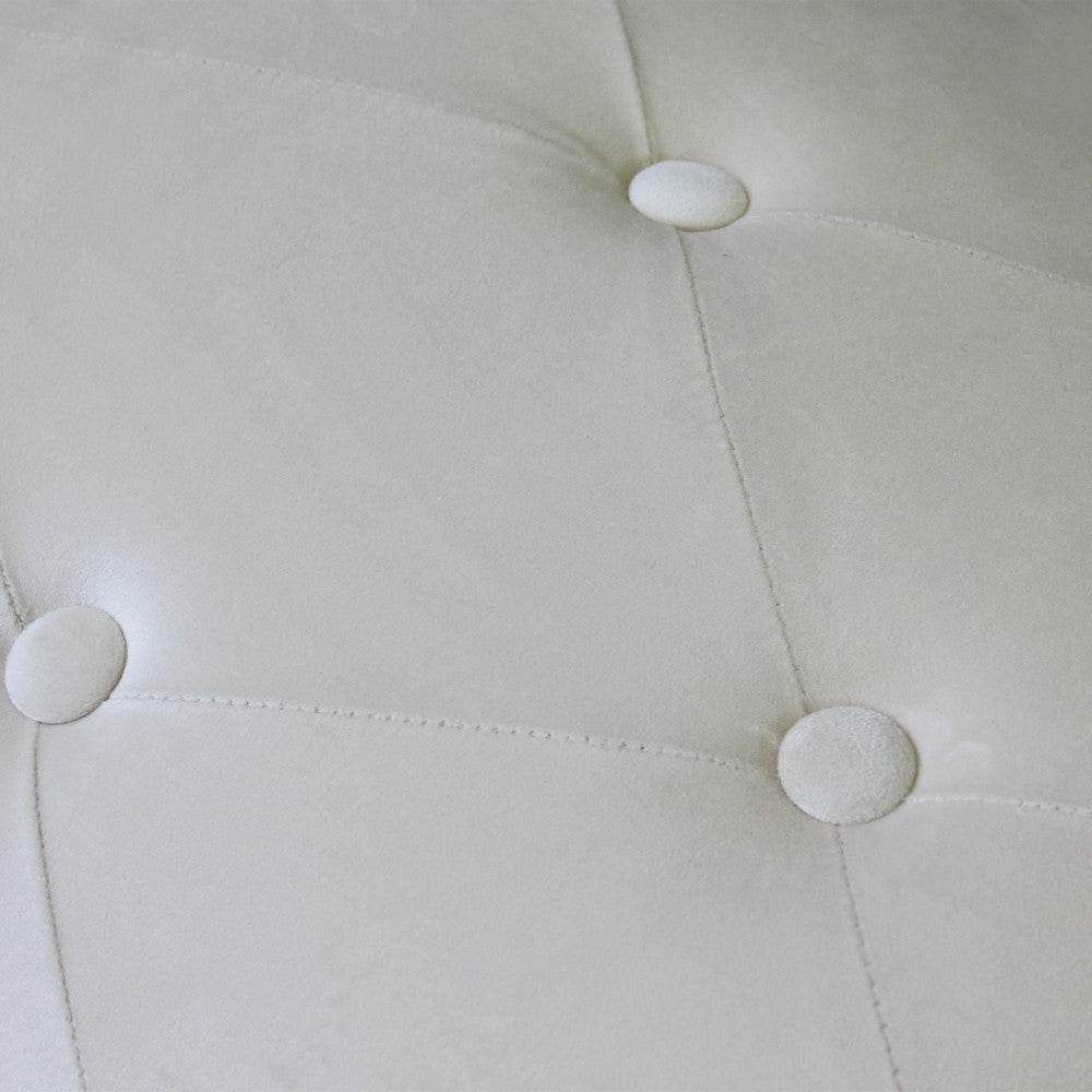 Dettaglio ravvicinato della texture in velluto beige e delle cuciture della lavorazione capitonné.