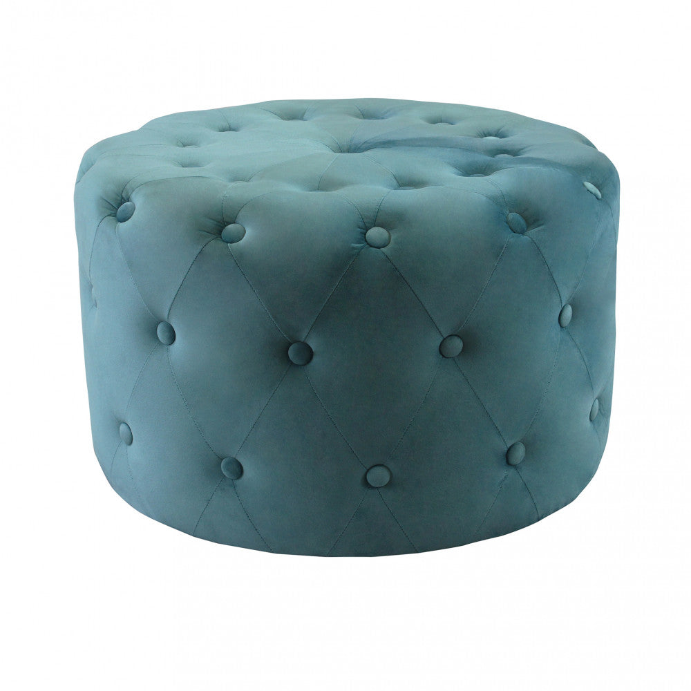 Vista frontale del pouf rotondo in velluto verde con elegante lavorazione capitonné su sfondo bianco.
