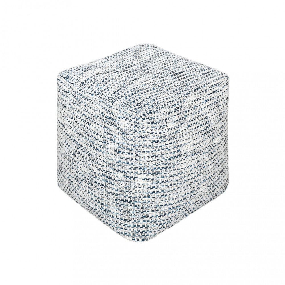 Vista isolata del Pouf Samuel a forma di cubo, che evidenzia la trama intrecciata in cotone blu e bianco su sfondo neutro.
