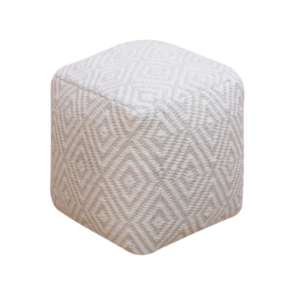 Vista isolata del pouf Simeon su sfondo bianco, che evidenzia la trama geometrica in lana e la struttura cubica.