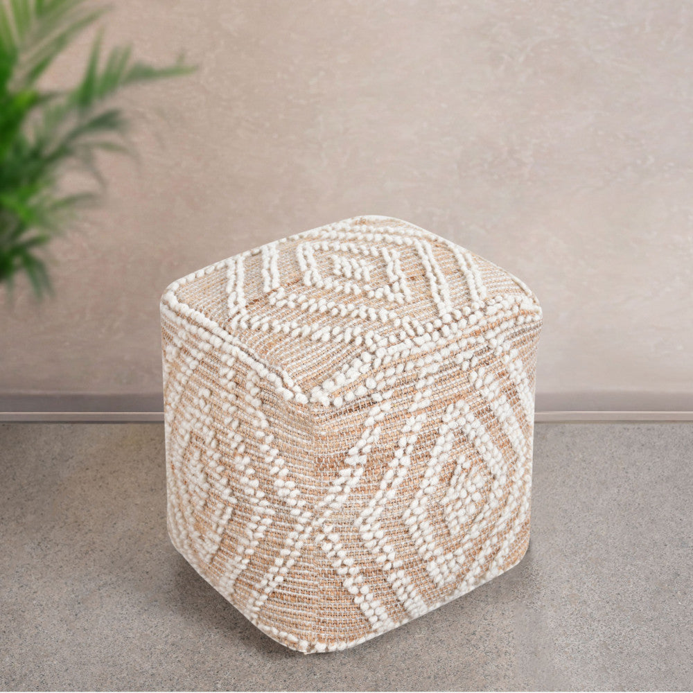 Pouf Térence ambientato in uno spazio minimalista con pavimento in pietra e una pianta decorativa sullo sfondo.