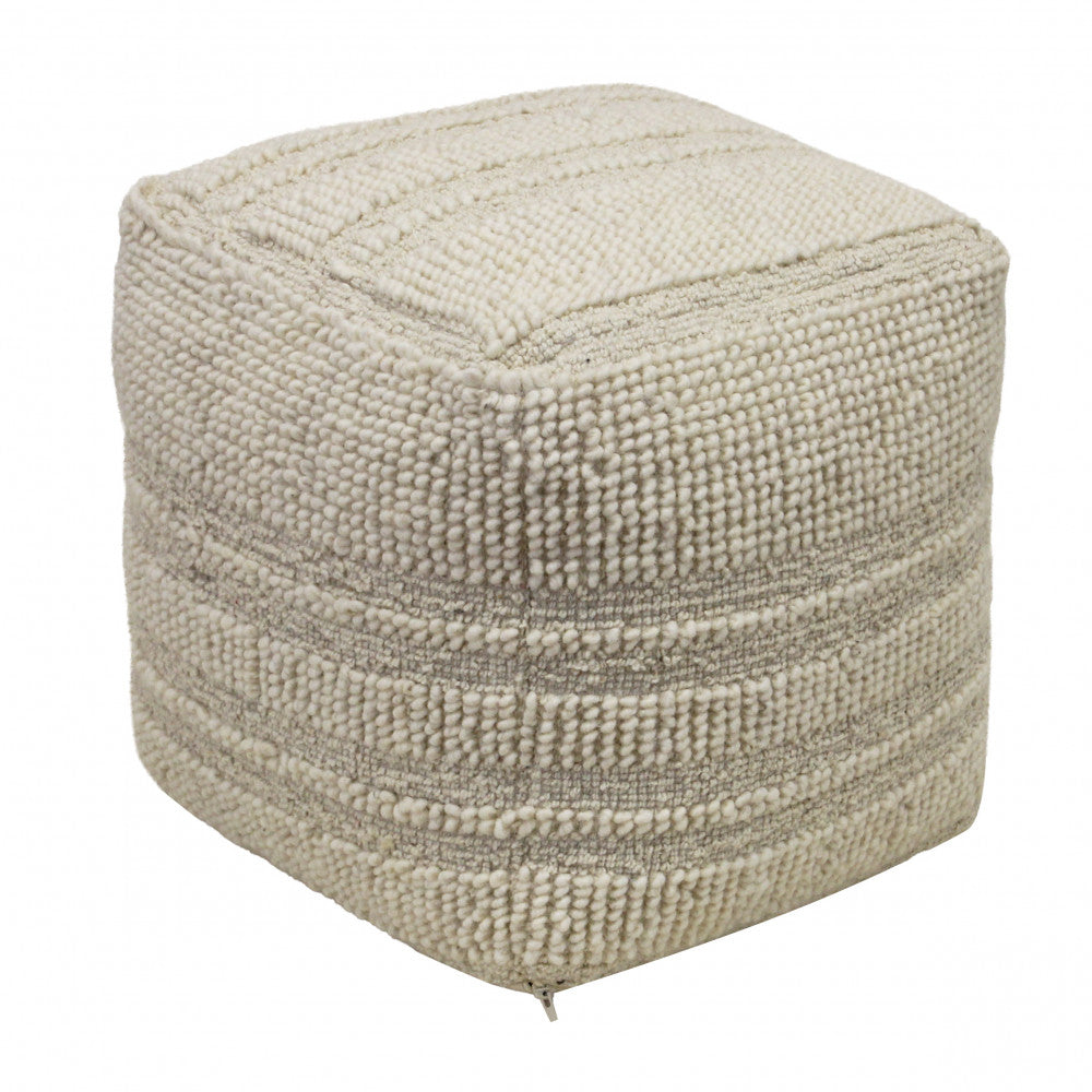 Pouf quadrato in lana bianca con texture tridimensionale a righe e nodi, vista angolare.