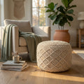 Pouf Tripoli in cotone bianco ambientato in un luminoso soggiorno boho chic accanto a una poltrona.