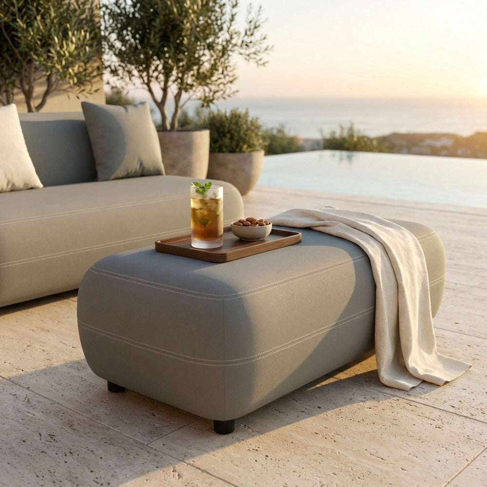 Dettaglio del pouf Tucumán in alluminio abbinato al divano della stessa collezione in un patio di lusso.