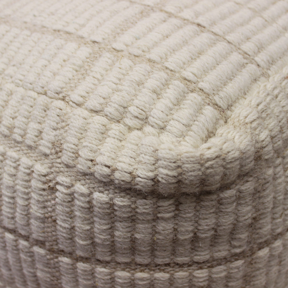 Dettaglio macro della trama in lana intrecciata del pouf, che mostra la lavorazione artigianale.
