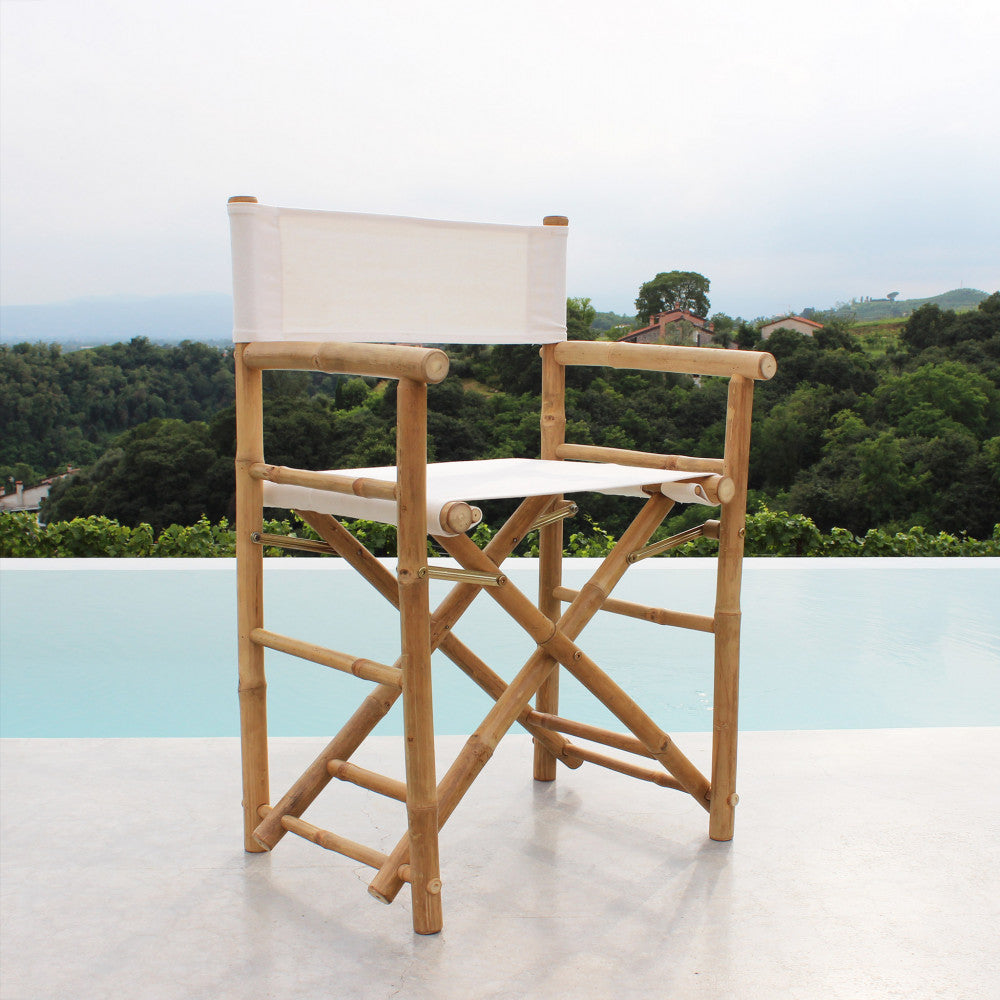 Sedia regista in legno a bordo piscina, con vista panoramica sulle colline.