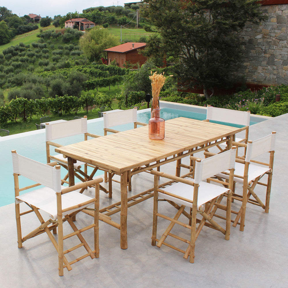 Set da pranzo all'aperto con tavolo in legno e sei sedie regista Mojito bianche a bordo piscina.