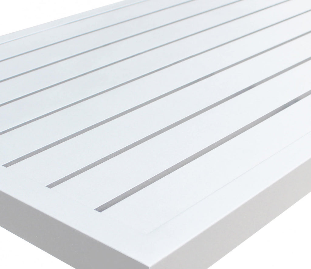 Primo piano della superficie a doghe del tavolino in alluminio bianco, evidenziando la finitura liscia e resistente.