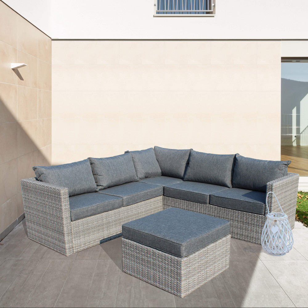Dettaglio del salotto angolare grigio posizionato in un patio moderno con pavimentazione in gres porcellanato.