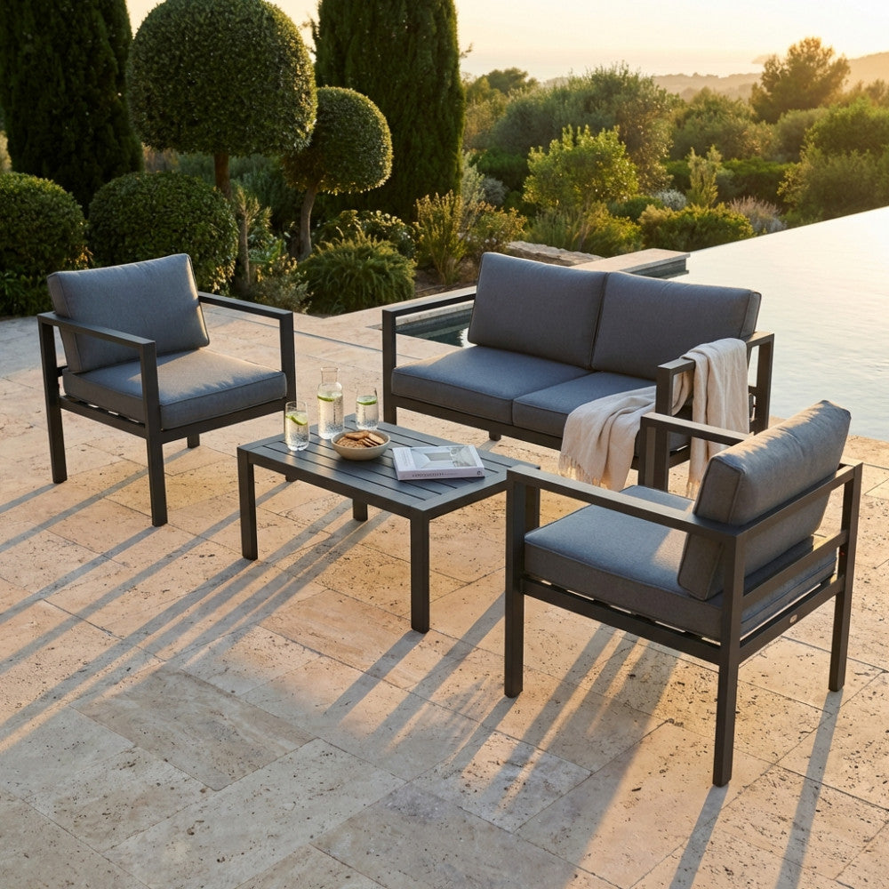 Salotto da esterno Avana 2 P in alluminio antracite allestito a bordo piscina al tramonto.