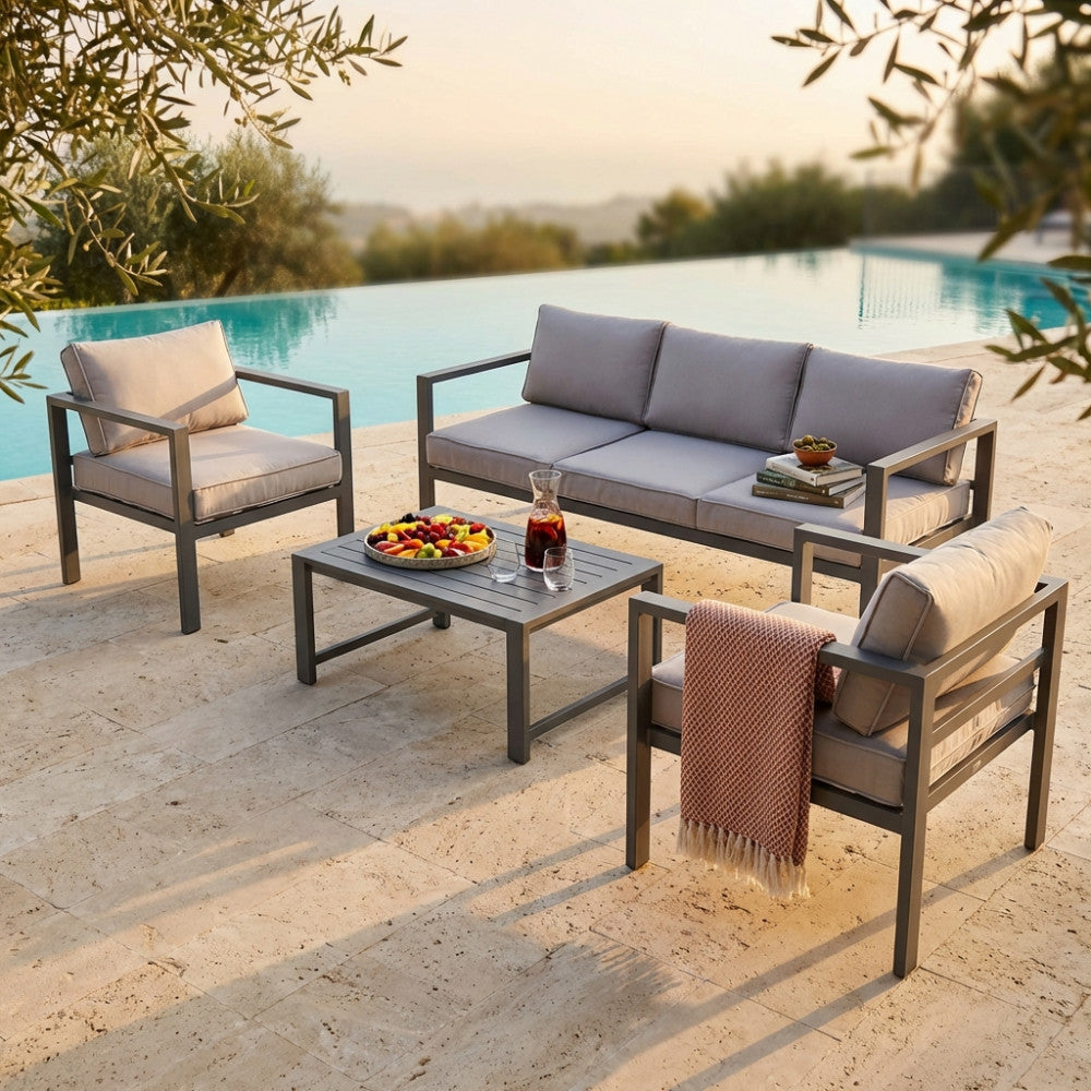 Salotto da esterno Avana a cinque posti in alluminio color taupe, allestito a bordo piscina durante il tramonto.